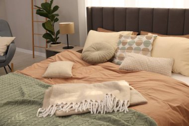 Yumuşak yastıkları ve odada battaniyesi olan büyük, rahat bir yatak. Ev tekstili