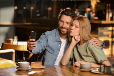 Romantik bir randevu. Kafede selfie çeken mutlu çift.