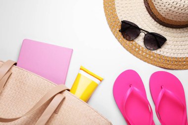 Beyaz arka planda güneş kremi ve plaj aksesuarları ile düz konum