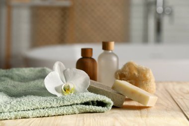 Banyodaki ahşap masanın üzerinde spa ürünleri olan kompozisyon, yakın plan.
