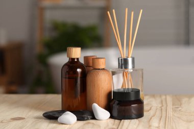 Banyodaki ahşap masanın üzerinde spa ürünleri olan kompozisyon, yakın plan.