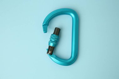 One carabiner on light blue background, top view clipart