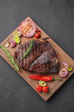 Gri desenli masada sebzelerle servis edilen leziz kızarmış et.