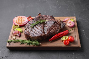 Gri dokulu masada sebzelerle servis edilen leziz kızarmış et.