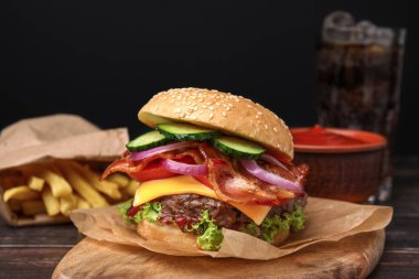 Pastırmalı, sebzeli ve ahşap masada köfteli leziz hamburger.