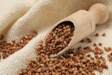 Beyaz kumaşta kuru karabuğday kepçesi, yakın plan.