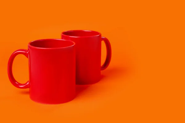 Дві Червоні Керамічні Чашки Помаранчевому Фоні Простір Тексту — стокове фото