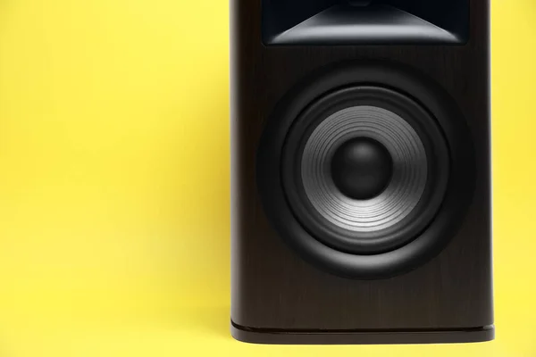 One wooden sound speaker on yellow background, closeup. Space for text