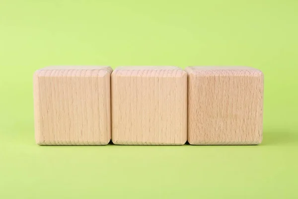 International Organization for Standardization. Wooden cubes with abbreviation ISO on light green background, closeup