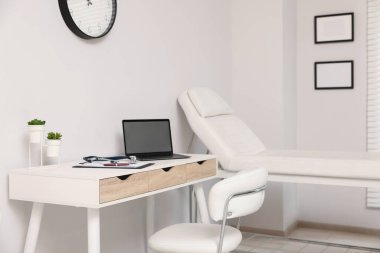 Doktorun çalışma alanı ve klinikte muayene masası olan modern tıp bürosu