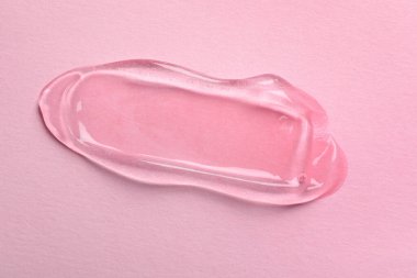 Pembe arka planda kozmetik jel örneği, üst görünüm