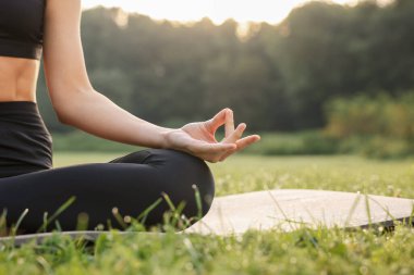 Dışarıdaki yoga minderinde Padmasana antrenmanı yapan bir kadın, yakın çekim ve mesaj için yer. Lotus pozu