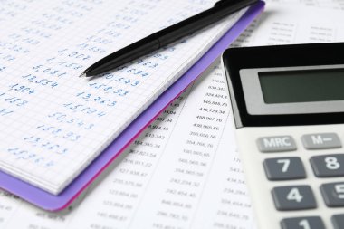 Belge üzerinde veri içeren hesap makinesi, defter ve kalem, kapat