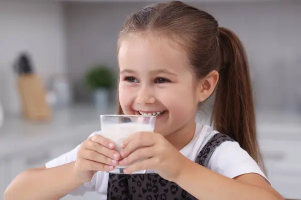 屋内で新鮮なミルクのガラスとかわいい女の子 — ストック写真