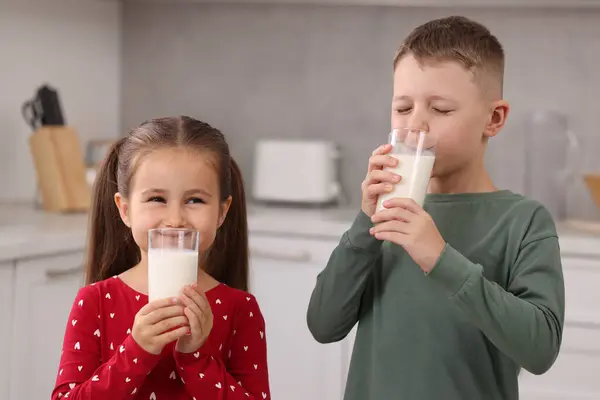 キッチンでメガネから新鮮なミルクを飲むかわいい子供たち — ストック写真