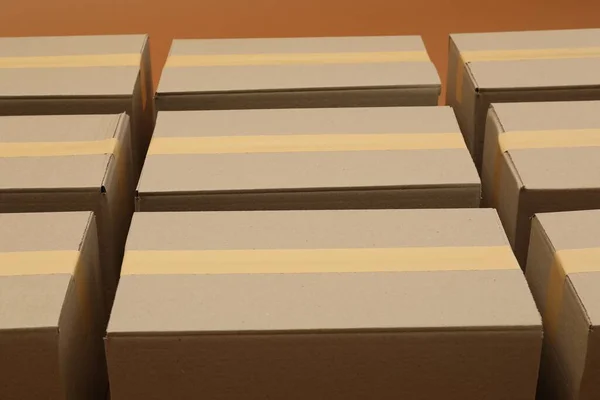 Many cardboard boxes on brown background, closeup