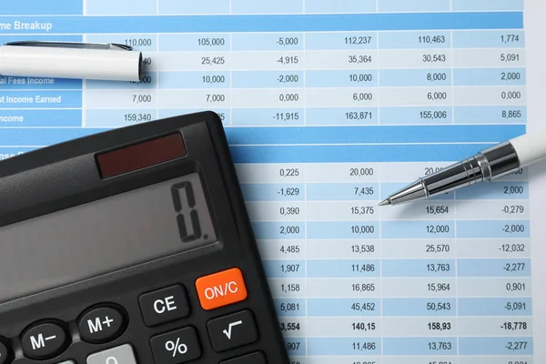 Calculator and pen on document with financial calculations, flat lay