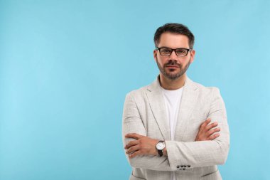 Açık mavi arka planda şık gözlüklü bir adamın portresi, metin için boşluk