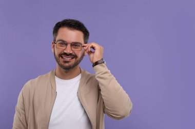 Mor arka planda gözlüklü mutlu adam portresi, metin için boşluk