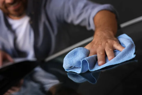 Man cleaning car windshield with rag, closeup