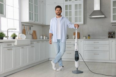 Mutfakta buhar paspası olan mutlu bir adam.