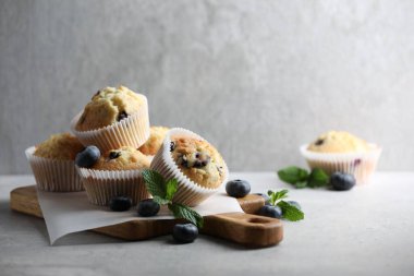 Yaban mersinli lezzetli çörekler ve gri masada nane şekeri, metin için yer var.