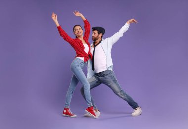 Mutlu çift menekşe arka planda dans ediyor.