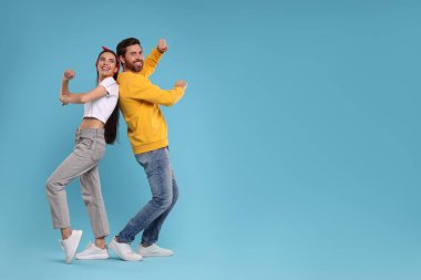 Açık mavi arka planda dans eden mutlu çift, mesaj için alan