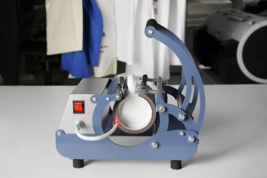 Yazıcı logosu. Beyaz masada bardaklı ısıtıcı.