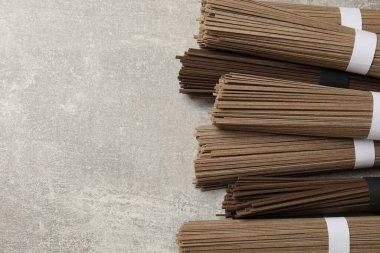 Açık gri masada pişmemiş karabuğday eriştesi (soba). Metin için boşluk