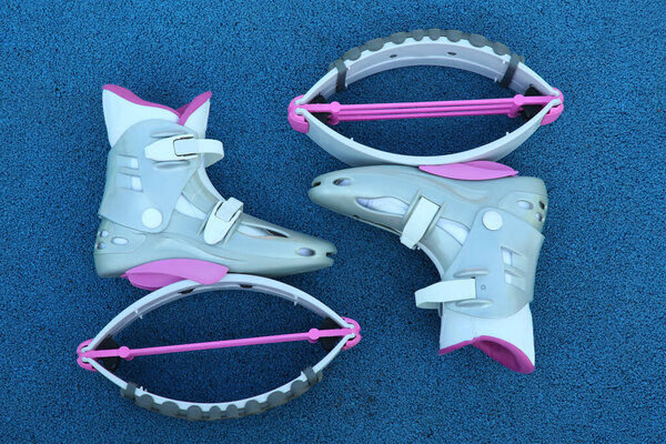 Stylish kangoo jumping boots on blue textured background, flat lay