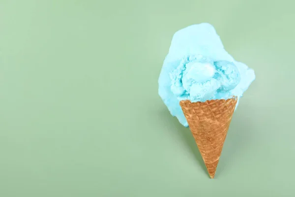 Melted ice cream and wafer cone on green background, top view. Space for text