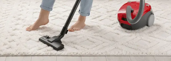 Woman cleaning carpet with vacuum cleaner at home, closeup. Banner design