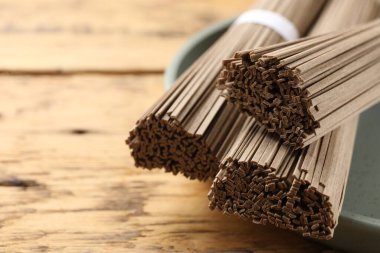 Ahşap masada pişmemiş karabuğday eriştesi (soba), yakın plan. Metin için boşluk