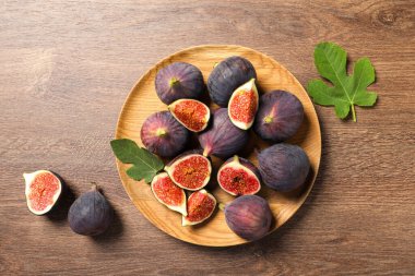 Tam ve olgun incirlerle ahşap masanın üzerinde düz bir şekilde yatıyordu.