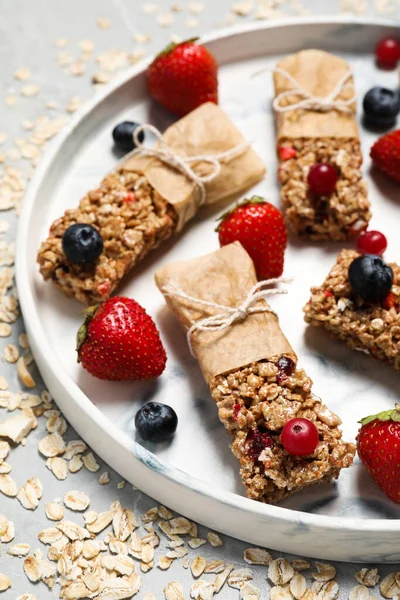 Lezzetli granola barlar ve malzemeler ışık masasında.