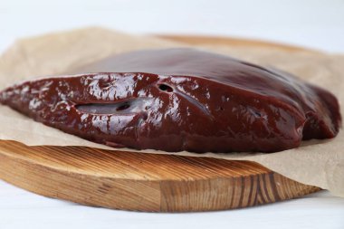 Beyaz masada çiğ sığır ciğeri var, yakın plan.