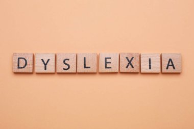 Soluk turuncu arka planda kelime disleksisi olan tahta küpleri düz yatıyordu.