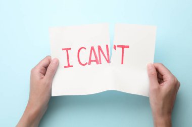Motivasyon konsepti. Bir kadın açık mavi arkaplanda kağıt yırtarak ifade verebilir.