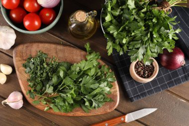 Taze yeşil maydanoz ve ahşap masada farklı ürünler.