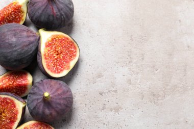 Açık gri desenli sehpada tam ve olgun incirleri düz bir şekilde kes. Metin için boşluk