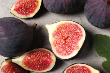 Açık gri desenli sehpada tam ve kesilmiş incir, düz yatıyordu.