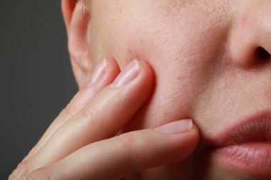 Gri arka planda sağlıklı cilde sahip kadının yakın görüntüsü