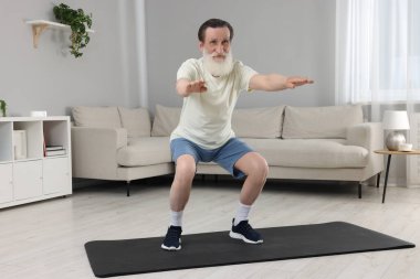 Spor giyim bölümündeki son sınıf öğrencisi evde egzersiz yapıyor.