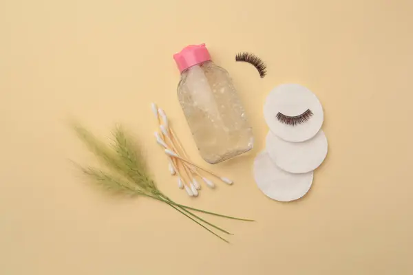 Flat lay composition with makeup remover and spikelets on yellow background