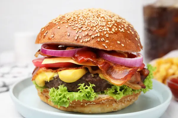Delicious burger with bacon, patty and vegetables on table, closeup