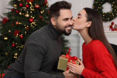 Güzel genç bir kadın erkek arkadaşına Noel hediyesi için teşekkür ediyor.