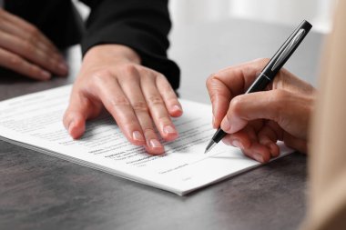 Yönetici, karanlık tabloda imza atacağı yeri gösterir, kapatır