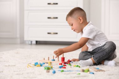 Motor beceri geliştirme. Küçük çocuk içeride istifleme ve sayma oyunlarıyla oynuyor.