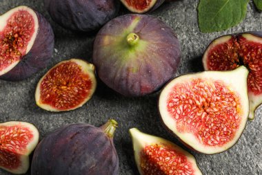 Gri desenli masa üzerinde bütün ve olgun incirler, düz yatıyordu.